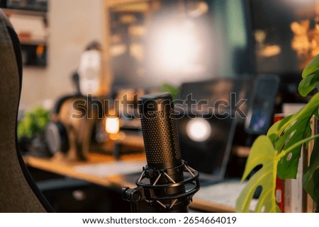 A warm and cozy desk setup featuring triple monitors, notebook, microphone, and green plants, styled in a minimalist Japanese aesthetic for creative work.