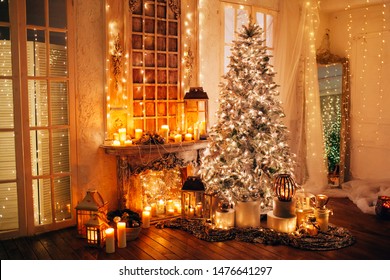 Warm Cozy Evening In Luxury Christmas Room Interior Design, Xmas Tree Decorated By Lights Presents Gifts Toys, Candles, Lanterns, Garland Lighting Fireplace.holiday Living Room. New Year Holidays