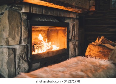 Warm Cozy Fireplace With Real Wood Burning In It. Cozy Winter Concept. Christmas And Travel Background With Space For Your Text.