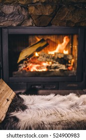 Warm Cozy Fireplace With Real Wood Burning In It. Cozy Winter Concept. Christmas And Travel Background With Space For Your Text.