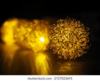 Warm decorative string lights featuring intricate wire‑mesh spheres glowing softly in a dark setting. Each image highlights a different focal point — from the front sphere to the middle and background lights