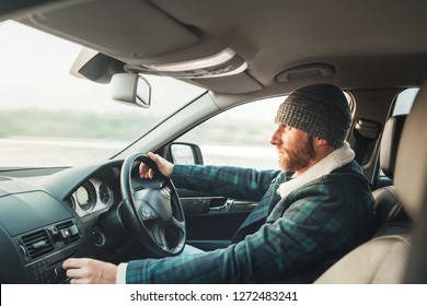 Warm Dressed Bearded Man Driving Modern Auto. Inside Car View. Winter Weather Driving 