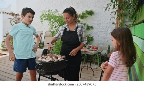 A warm family moment as a mother grills seafood while her children watch, in a lush backyard. - Powered by Shutterstock