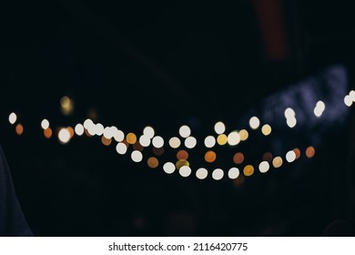 Warm Festive Bokeh Of String Lights Over An Outdoor Bar And Restaurant Patio At Twilight