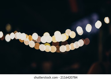 Warm Festive Bokeh Of String Lights Over An Outdoor Bar And Restaurant Patio At Twilight