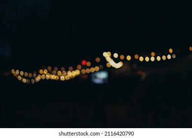 Warm Festive Bokeh Of String Lights Over An Outdoor Bar And Restaurant Patio At Twilight