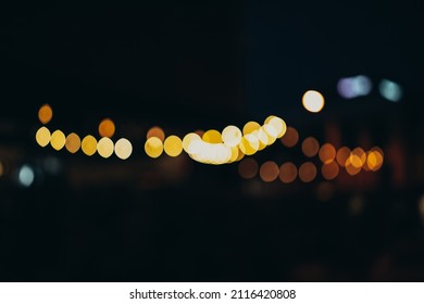 Warm Festive Bokeh Of String Lights Over An Outdoor Bar And Restaurant Patio At Twilight