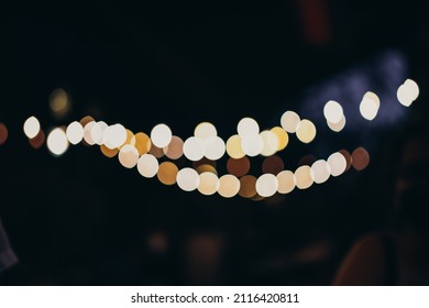 Warm Festive Bokeh Of String Lights Over An Outdoor Bar And Restaurant Patio At Twilight