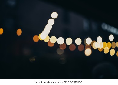 Warm Festive Bokeh Of String Lights Over An Outdoor Bar And Restaurant Patio At Twilight