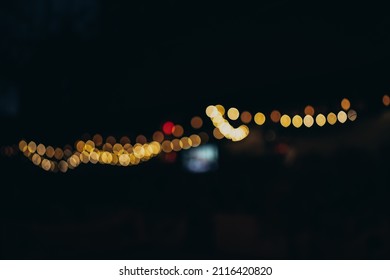 Warm Festive Bokeh Of String Lights Over An Outdoor Bar And Restaurant Patio At Twilight