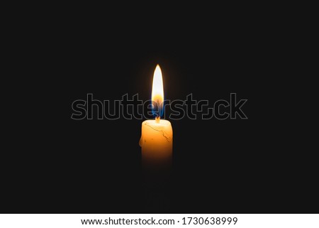 Warm Flame From A Candle Light On a Dark Background