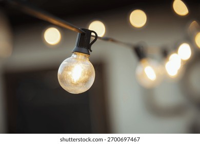 Warm glowing string lights create a cozy atmosphere in an outdoor space - Powered by Shutterstock - Get 15% off with code: PIKWIZARD15