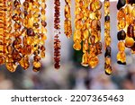 Warm gold colored amber jewelry necklaces on display at Mariacka street in Gdansk. Cose up picture of amber jewelry.