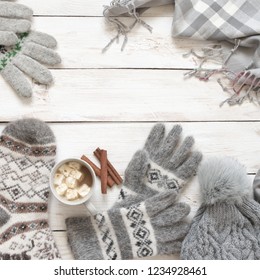 Warm Grey Woolen Knitwear: Socks, Gloves, Pom Hat, Scarf And Cup Of Cocoa With Marshmallow On White Rustic Wood Background. Winter Cozy Still Life. 