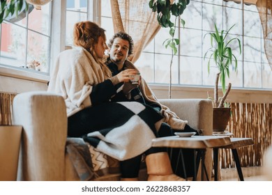 A warm interaction between two people sitting together, enjoying a tranquil moment indoors.