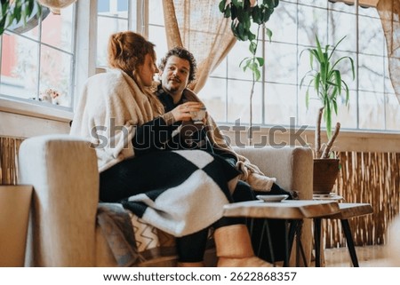 A warm interaction between two people sitting together, enjoying a tranquil moment indoors.