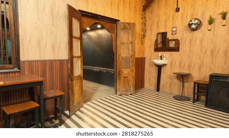 Warm interior of a rustic cafe featuring traditional wooden doors, striped flooring, a washbasin, and wooden furniture.