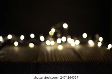 Warm LED Fairy Lights Bokeh on Wooden Surface Against Dark Background - Powered by Shutterstock