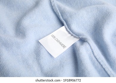 Warm light blue cashmere sweater with label, closeup