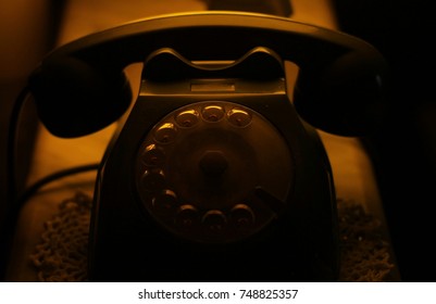 Warm light and dark of an old fixed phone 