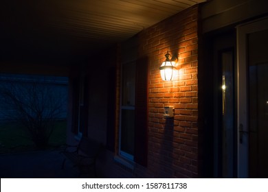 Warm Light Lantern Illuminating The Front Porch At Night