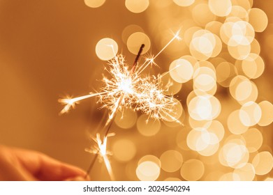 Warm lights as abstract bokeh made from Christmas lights with sparkling Sparkler. Holiday concept, blur bokeh, postcard concept.