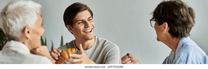 A warm morning as a lesbian couple and their adult son share smiles and breakfast in their home. - Powered by Shutterstock