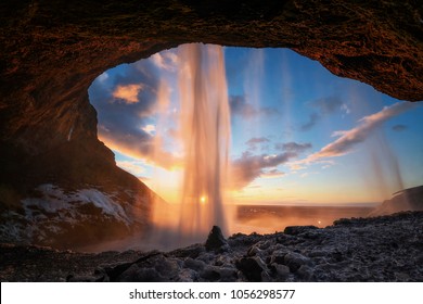 Warm photo of Seljalandsfoss view from inside in evening light before sunset, Iceland