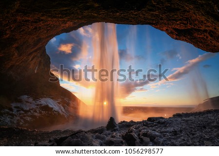 Warm photo of Seljalandsfoss view from inside in evening light before sunset, Iceland
