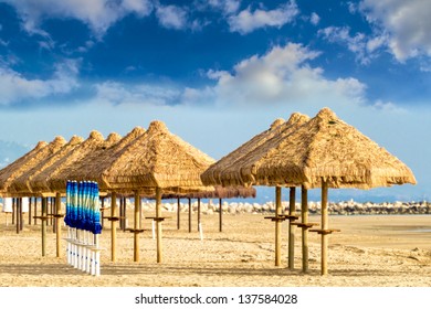The warm rays of sunshine in late spring are projected on a deserted beach still awaiting the summer with tourists.