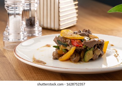 Warm Salad With Veal, Tomatoes, Peppers, Cucumber And Mushrooms On Wooden Background. Restaurant Food, Close Up. Meat Salad. Close Up View On Salad With Warm Baked Veal.