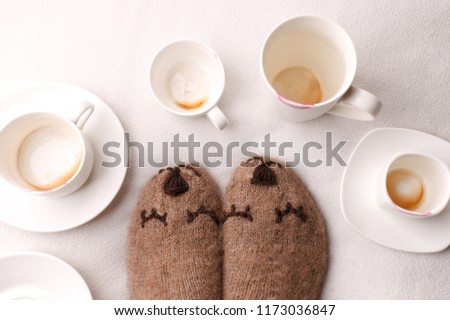 Warm soft blanket, many empty cups of espresso coffee, woolen socks. Winter fall autumn cozy still life. Lazy sleepy weekend morning concept. Top view point. Copy space 