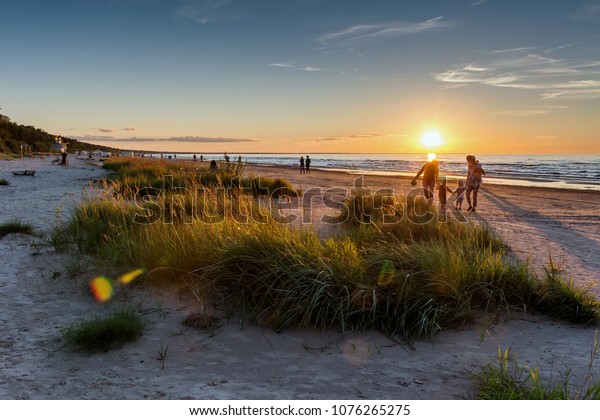 暖かい夏の夕日 背景にビーチの風景と人のシルエット ジュルマラリゾート ラトビア バルト海 休暇のコンセプト の写真素材 今すぐ編集