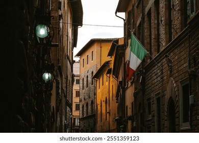 Warm sunset light illuminating colorful buildings in a narrow street of florence, with an italian flag hanging from a building and vintage street lamps adding to the charming atmosphere - Powered by Shutterstock