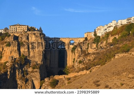 The warm sunset light over the Puente Nuevo, the bridge built over the deep canyon that divides the city of Ronda, Spain