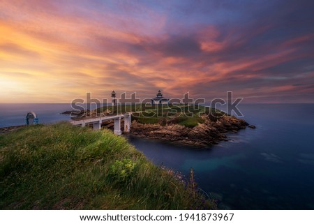 Warm sunset over the Illa Pancha lighthouse, on the Lugo coast, Galicia.