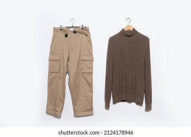 Warm Sweaters With Khaki Pants On Hanging On The Gray Background