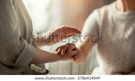 Warm, tender image capturing a compassionate moment as one person gently holds and supports another's hand. The soft focus and natural lighting evoke an atmosphere of empathy, care, and emotional connection, making this photo ideal for illustrating concepts such as support, healing, trust, and mental health in a lifestyle or wellness context.