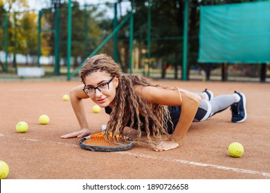 Warm Up With Tennis Racket Before Starting Your Workout. The Charming Tennis Player Warms Up The Muscles Before Giving Them Physical Activity. Tennis Can Be Traumatic If The Precautions Are Not Taken.