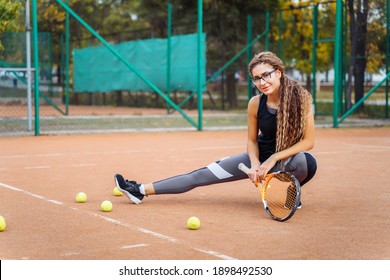 Warm Up With Tennis Racket Before Starting Your Workout. The Charming Tennis Player Warms Up The Muscles Before Giving Them Physical Activity. Tennis Can Be Traumatic If The Precautions Are Not Taken.