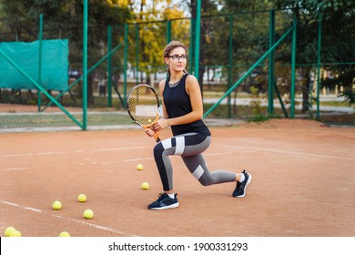 Warm Up With Tennis Racket Before Starting Your Workout. The Charming Tennis Player Warms Up The Muscles Before Giving Them Physical Activity. Tennis Can Be Traumatic If The Precautions Are Not Taken.