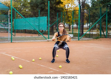 Warm Up With Tennis Racket Before Starting Your Workout. The Charming Tennis Player Warms Up The Muscles Before Giving Them Physical Activity. Tennis Can Be Traumatic If The Precautions Are Not Taken.