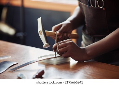 warm toned closeup of female artisan punching holes in handmade leather belt at workshop, copy space - Powered by Shutterstock