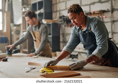 Warm toned portrait of artisan carpenters sanding wood and building handmade furniture pieces in workshop, copy space - Powered by Shutterstock