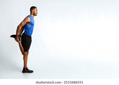 Warm Up. Side view of black man stretching legs before run over yellow studio wall, full length, copyspace - Powered by Shutterstock