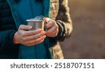 Warm up. Woman holding camping cup with hot drink, cropped