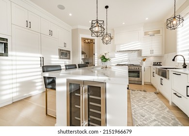 Warm White Kitchen With Expansive Countertops Island High End Appliances Spice Kitchen Black Leather Chair Dining Table Wine Fridge And Office Work Station