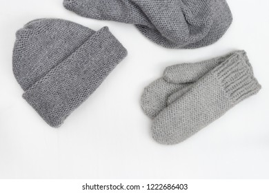 Warm winter women's clothing, knitted mittens, knitted hat, knitted scarf. Top view. Copy space.