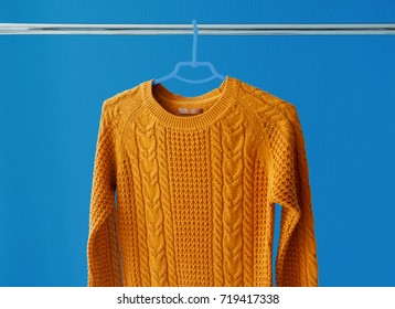 Warm Woolen Sweater Hanging On Hanger