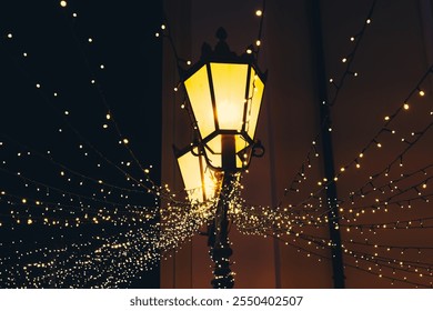 Warm yellow light from elegant lanterns blends with sparkling fairy lights, creating a magical atmosphere on a bustling street at night. - Powered by Shutterstock